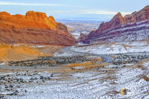 Welcome to Reinventing Moments 4 Take in the breathtaking view of the 1-70 curve through Green River, Utah with a semi-truck making its way through the stunning canyon landscape in the background
