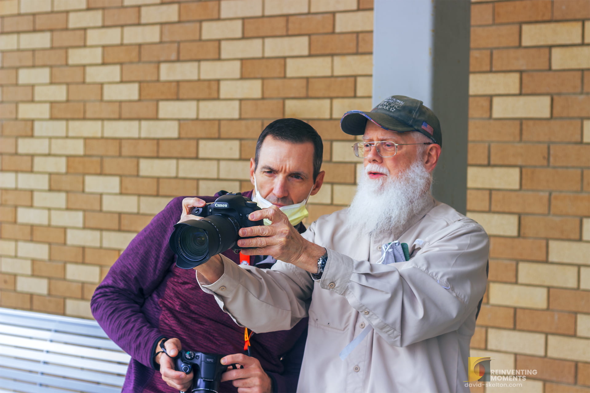 wo men are seen on an outdoor patio, one teaching the other the art of outdoor photography. The image showcases the natural beauty surrounding the Veteran Clinic in Loma Linda, CA.