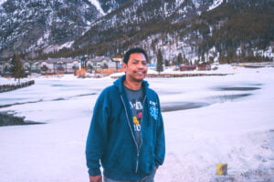Four Corners Road Trip 2.0: Reliving Our Southwest Adventure 6 Gio in winter gear smiles at the camera with snow-covered Copper Creek Golf Course and Copper Mountain in the background.