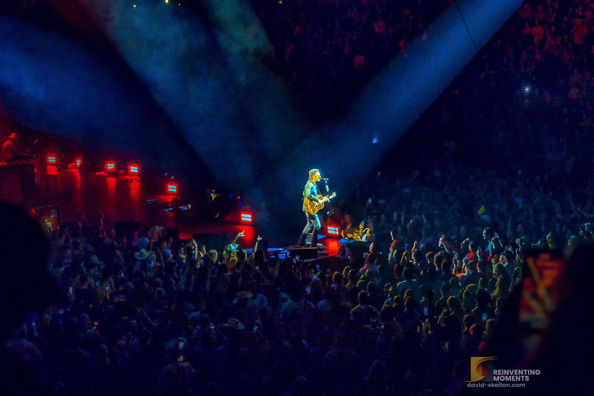Eric Church performing live at Crypto.com Arena, May 2022. He's playing guitar and singing, illuminated by spotlights.