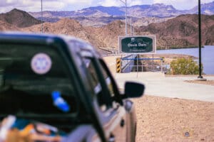 Vegas Jets and River Runs 2 Davis Dam Welcome Sign, blurred Nissan Frontier in foreground.