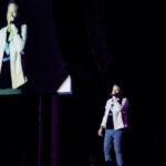 Gary Allan performing live on stage at Sycuan Casino Resort, El Cajon, CA. He is holding his guitar and singing into the microphone, with stage lights illuminating him and his band