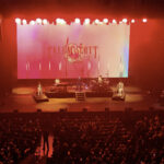 Calum Scott singing "No Matter What" on stage at the Yaamava Resort & Casino, with his drummer and keyboard player on either side of him.
