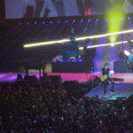Keith Urban playing electric guitar on stage at the Kia Forum in Inglewood, California, during "The Speed Of Now World Tour" in 2022.