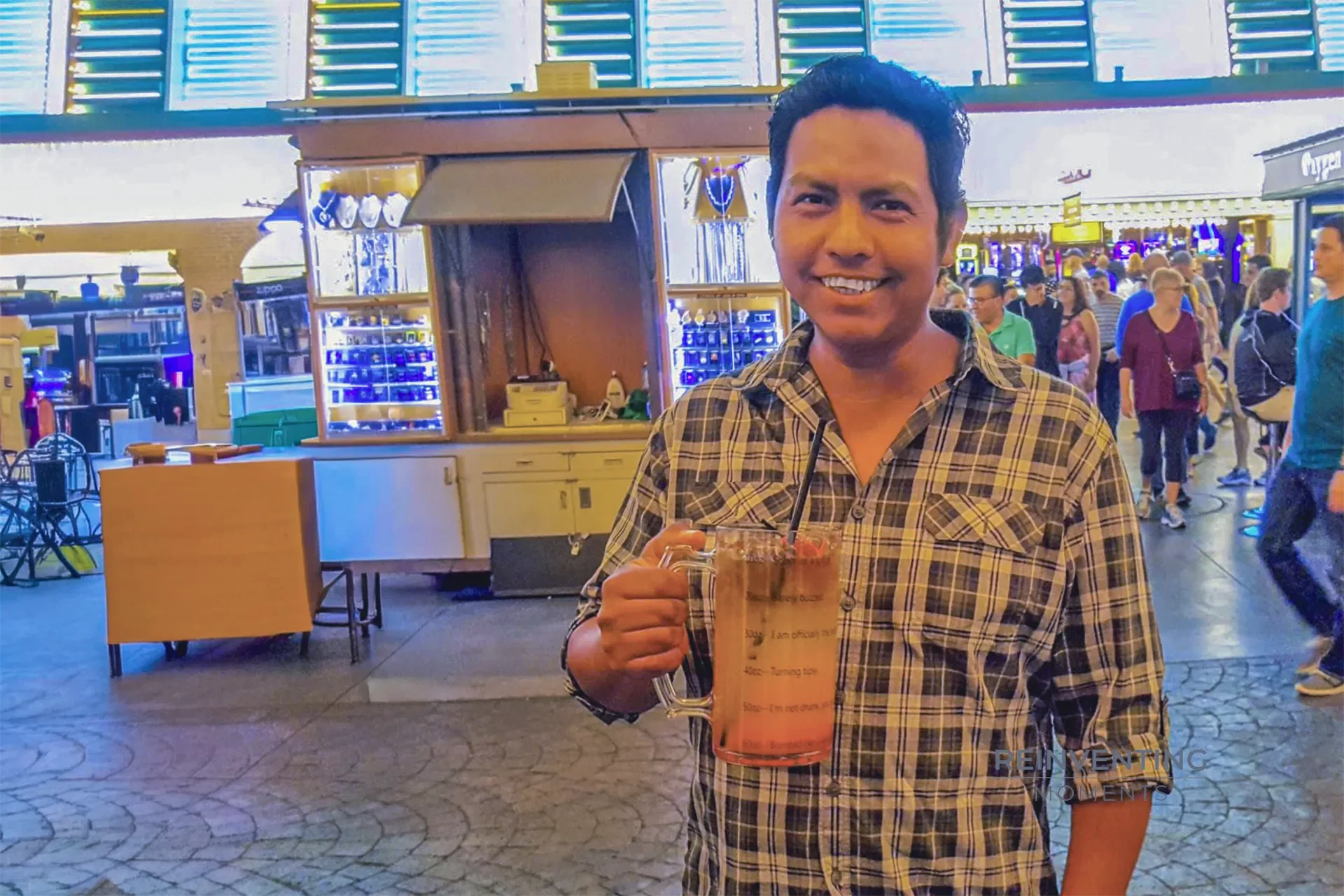 Gio holding a large souvenir beer boot drink mug under the glowing neon lights of the Fremont Street Experience in Downtown Las Vegas.